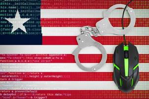 drapeau du libéria et souris d'ordinateur menottée. lutte contre la criminalité informatique, les hackers et le piratage photo