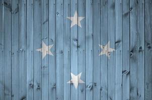 drapeau de la micronésie représenté dans des couleurs de peinture vives sur un vieux mur en bois. bannière texturée sur fond rugueux photo