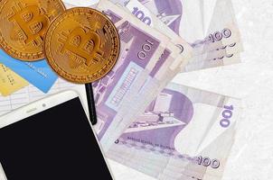 100 billets de piso philippins et bitcoins dorés avec smartphone et cartes de crédit. concept d'investissement en crypto-monnaie. minage ou commerce de crypto photo
