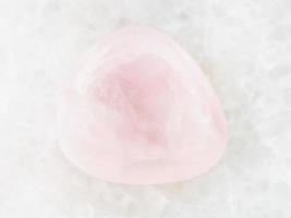 pierre précieuse de quartz rose dégringolé sur du marbre blanc photo