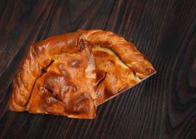 le gâteau maison coupé en deux morceaux repose sur une surface en bois. photo