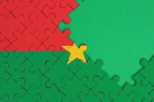 le drapeau du burkina faso est représenté sur un puzzle terminé avec un espace de copie vert gratuit sur le côté droit photo