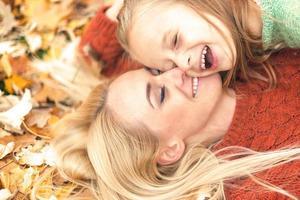 fille et maman allongées sur les feuilles d'automne photo