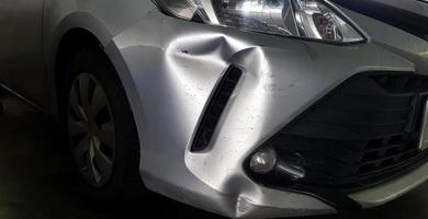 rayures ou bosses sur une voiture grise, grise ou bronze après accident. endommagé sur blessé sur le pare-chocs avant. photo