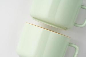 un ensemble de tasses à thé en céramique blanche et vert pastel aux contours orange