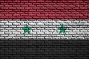 le drapeau de la syrie est peint sur un vieux mur de briques photo