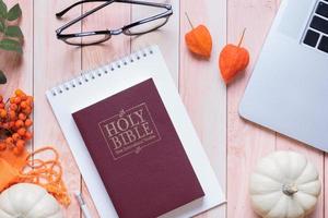 sainte bible et automne confortable vue de dessus sur fond en bois. concept d'automne d'étude biblique photo
