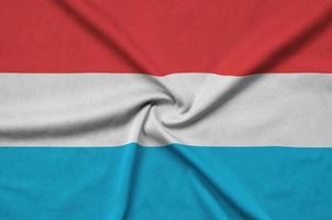 le drapeau luxembourgeois est représenté sur un tissu de sport avec de nombreux plis. bannière de l'équipe sportive photo
