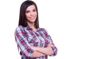 portrait de beauté et de confiance. belle jeune femme souriante regardant la caméra et souriant tout en gardant les bras croisés et debout isolé sur blanc photo