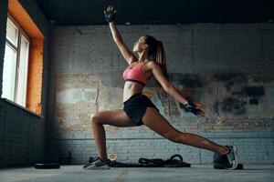 belle jeune femme à la recherche concentrée tout en faisant de l'exercice dans la salle de gym photo