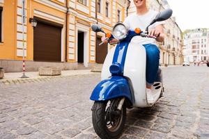 rouler avec plaisir. image recadrée d'un jeune homme heureux faisant du scooter le long de la rue photo