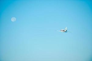 voler vers la lune. vue en contre-plongée d'un avion volant en direction de la lune photo