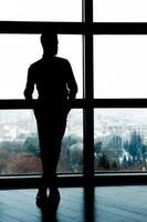silhouette d'entreprise. silhouette pleine longueur d'homme d'affaires debout devant la fenêtre photo