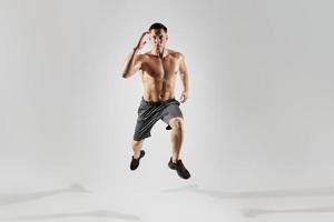 homme musclé concentré avec un corps parfait courant sur fond blanc photo