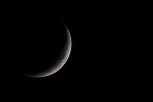 croissant de lune avec un ciel d'hiver sombre peu après le coucher du soleil photo