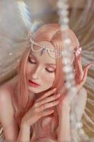 portrait de beauté d'une femme elfe princesse anime aux cheveux roses en sous-vêtements. fabuleux look magique, beau maquillage rose. couronne de jante sur la tête d'une femme photo