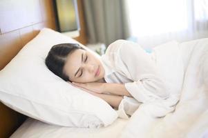 belle jeune femme endormie dans son lit à la maison photo