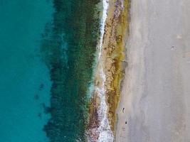 vue aérienne de la mer, vue de dessus, fond de nature incroyable. couleur de l'eau et belle luminosité. rivage rocheux et eau claire de la mer par une journée ensoleillée drone volant, paysage marin photo