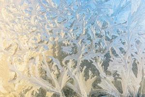 fenêtre d'hiver gelée avec texture de motif de givre brillant. symbole de merveille de noël, arrière-plan abstrait. extrême nord basse température, neige glacée naturelle sur verre givré, temps d'hiver frais à l'extérieur. photo