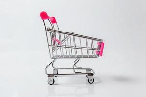 petit chariot d'épicerie de supermarché pour faire du shopping jouet avec roues isolé sur fond blanc. vente acheter concept de consommateur de magasin de marché de centre commercial. espace de copie. photo