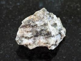 Pierre de gneiss brut sur fond sombre photo