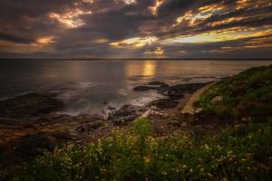 coucher de soleil sur un rivage rocheux. photo
