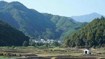 les beaux paysages de montagnes avec la forêt verte et le petit village en arrière-plan dans la campagne de la chine photo