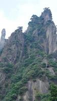 les beaux paysages de montagnes avec la forêt verte et la falaise rocheuse en éruption en arrière-plan dans la campagne de la chine photo