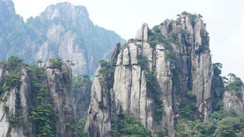 les beaux paysages de montagnes avec la forêt verte et la falaise rocheuse en éruption en arrière-plan dans la campagne de la chine photo