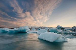 Icebergs dans le lac glaciaire de Jokulsarlon au coucher du soleil photo