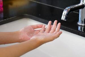les enfants asiatiques se lavent les mains avec du savon après avoir quitté les toilettes dans le concept d'hygiène, préviennent les germes et le virus corona. mise au point douce et sélective. photo