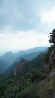 les beaux paysages de montagnes avec la forêt verte et une route en planches construite le long d'une falaise dans la campagne de la chine photo