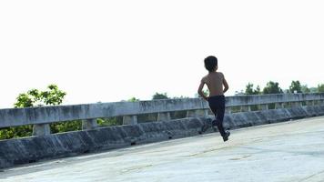 un petit garçon fort a couru le long du pont. photo