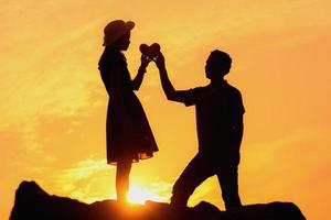 heureux jeune couple ensemble contre le beau coucher de soleil. liberté, photo