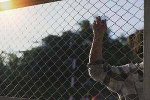 photo en gros plan des mains en prison poignée en treillis d'acier gère la cage en treillis d'acier, manque d'indépendance.