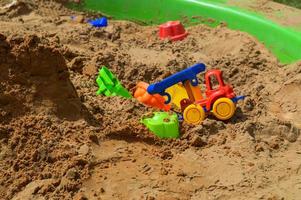 bac à sable pour enfants sur l'aire de jeux pour jeux avec jouets pour enfants en camion, voiture, excavatrice, dresseurs de sable avec une spatule photo