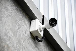 caméra de vidéosurveillance ip installée sur un poteau en bois à l'extérieur de la maison pour assurer la sécurité en surveillant via un téléphone mobile et d'autres appareils intelligents pour sauver la propriété et la vie humaine. photo