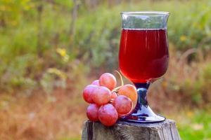 verre de vin rouge et grappe de raisin sur table en bois photo