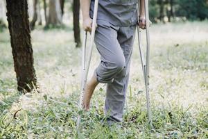 jeune physiothérapeute asiatique travaillant avec une femme âgée sur la marche avec un déambulateur photo