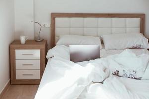concept d'isolement de la maison de travail. ordinateur portable au lit photo