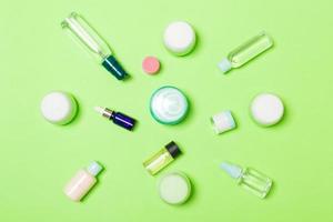 groupe de bouteille de soin du corps en plastique composition à plat avec des produits cosmétiques sur fond vert espace vide pour votre conception. ensemble de contenants cosmétiques blancs, vue de dessus avec espace de copie photo