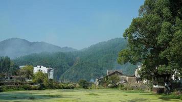 la belle vue sur le village chinois traditionnel avec l'architecture classique et les arbres verts frais en arrière-plan photo