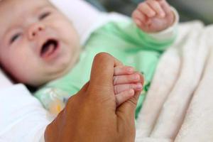 la main de la mère tient la petite main de son enfant. photo