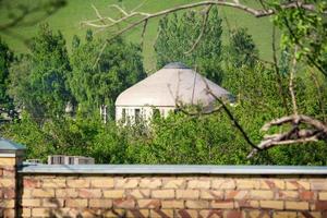 yourte blanche parmi les arbres verts sur une colline. traditions asiatiques photo