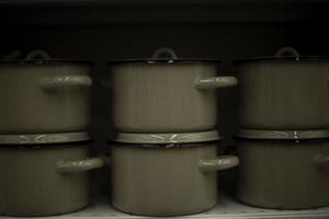 beaucoup de casseroles. ustensiles de cuisine sur étagère. vente d'ustensiles. casseroles en acier. détails de la vente des marchandises. photo