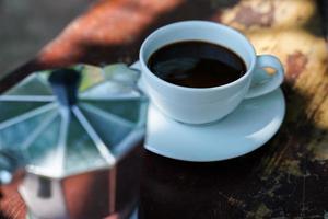 café noir chaud dans une tasse blanche, le café est une boisson populaire dans le monde entier. photo