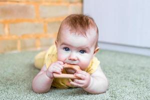 petite fille caucasienne avec jouet de dentition en bois. jouets écologiques pour les enfants. photo