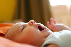 portrait d'enfant sur un lit le matin en contre-jour. photo