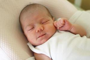 mignon bébé nouveau-né dort sur son lit. photo