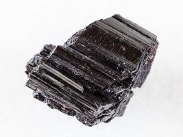 cristal brut de tourmaline noire schorl sur blanc photo